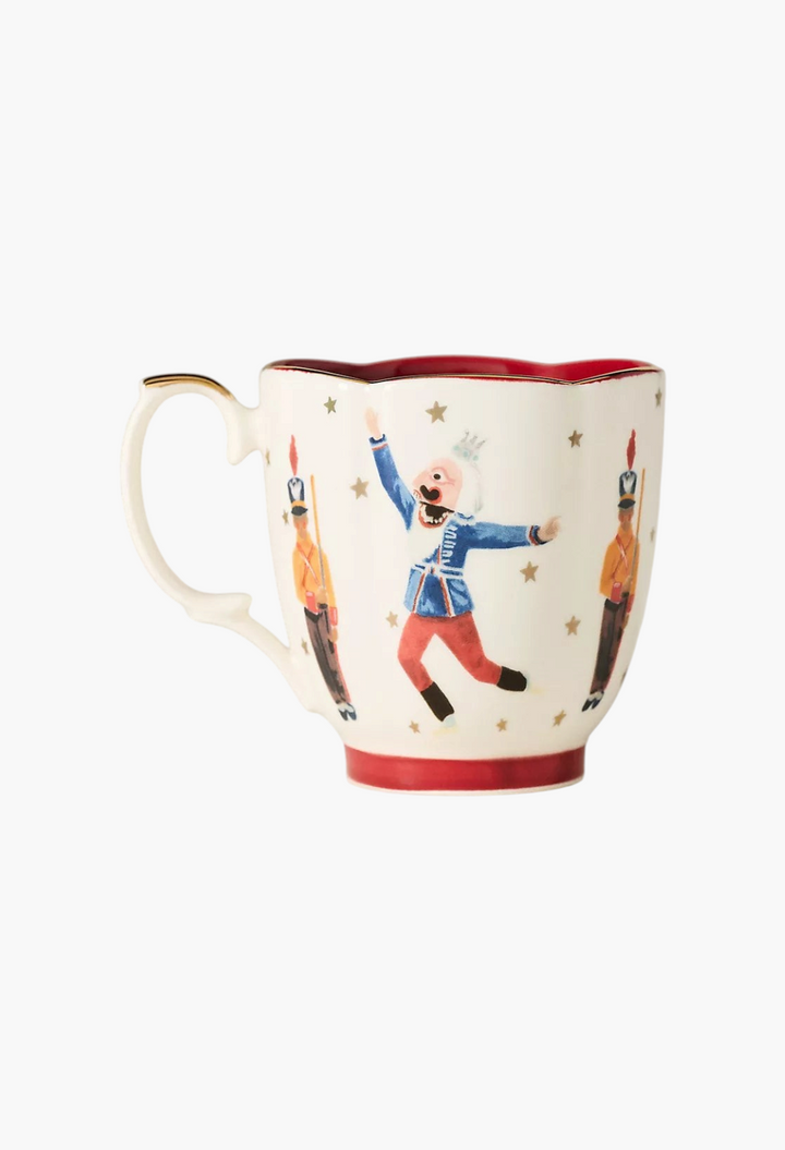 GLAM MODA stoneware mug featuring a Nutcracker ballet design with gold stars and a red interior rim
