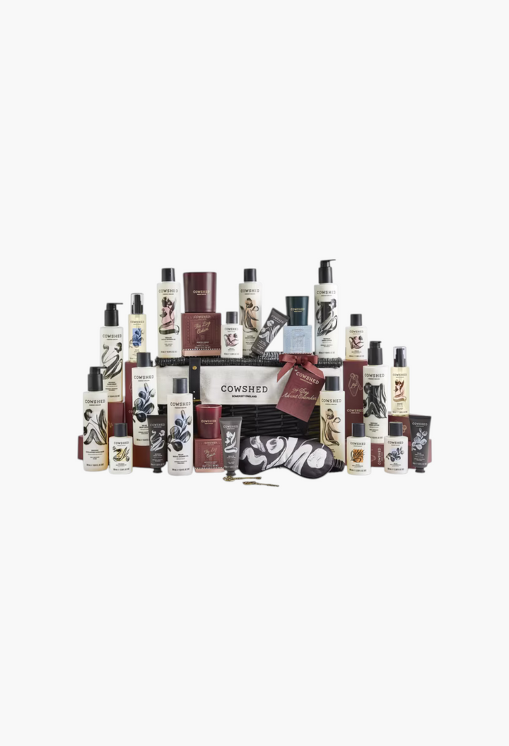 GLAM MODA Cowshed 24 Day Advent Calendar featuring body, hand, and home care products in a monochrome wicker hamper.