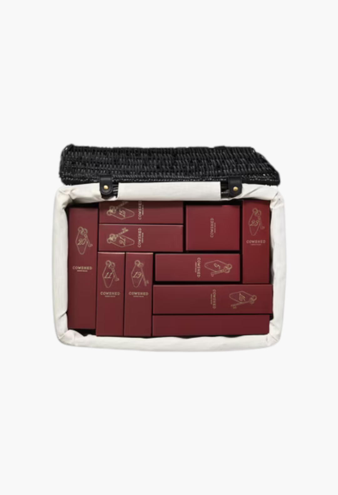 GLAM MODA Cowshed 24 day advent calendar featuring numbered deep red boxes inside a black handwoven wicker hamper