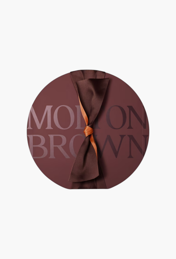 GLAM MODA Decadent Delights Advent Calendar in a round dark chocolate box with an elegant brown satin ribbon bow