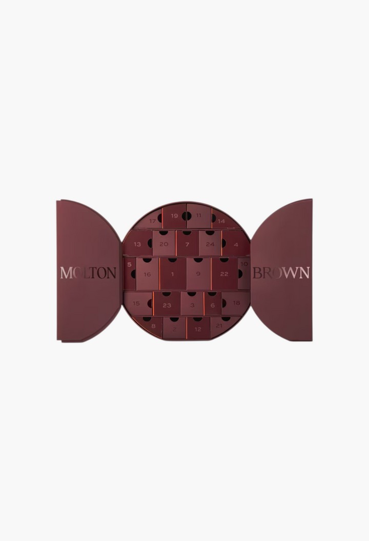 GLAM MODA Decadent Delights Advent Calendar in a deep red circular box with numbered drawers and open side panels.