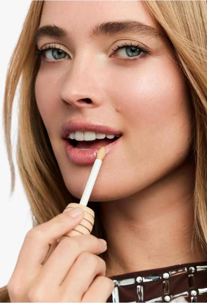 GLAM MODA model applying Rêve de Miel Honey Lip Care with a wand applicator for a natural glossy finish