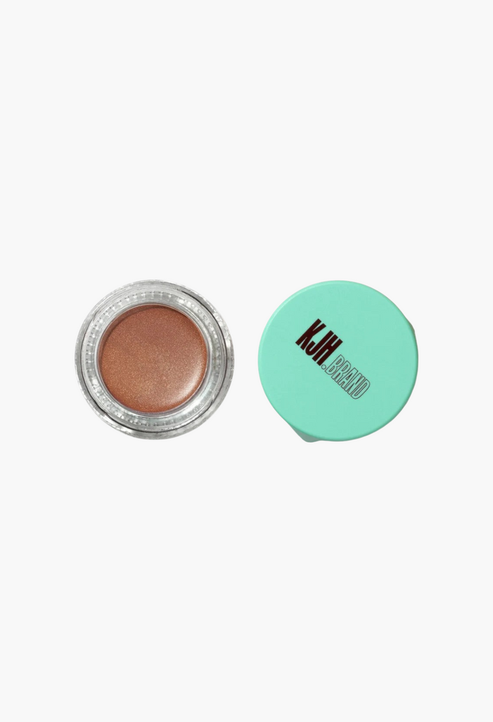 GLAM MODA Hyper Shine Lite Pigment in a shimmering bronze shade with a teal lid, shown in an open glass jar.