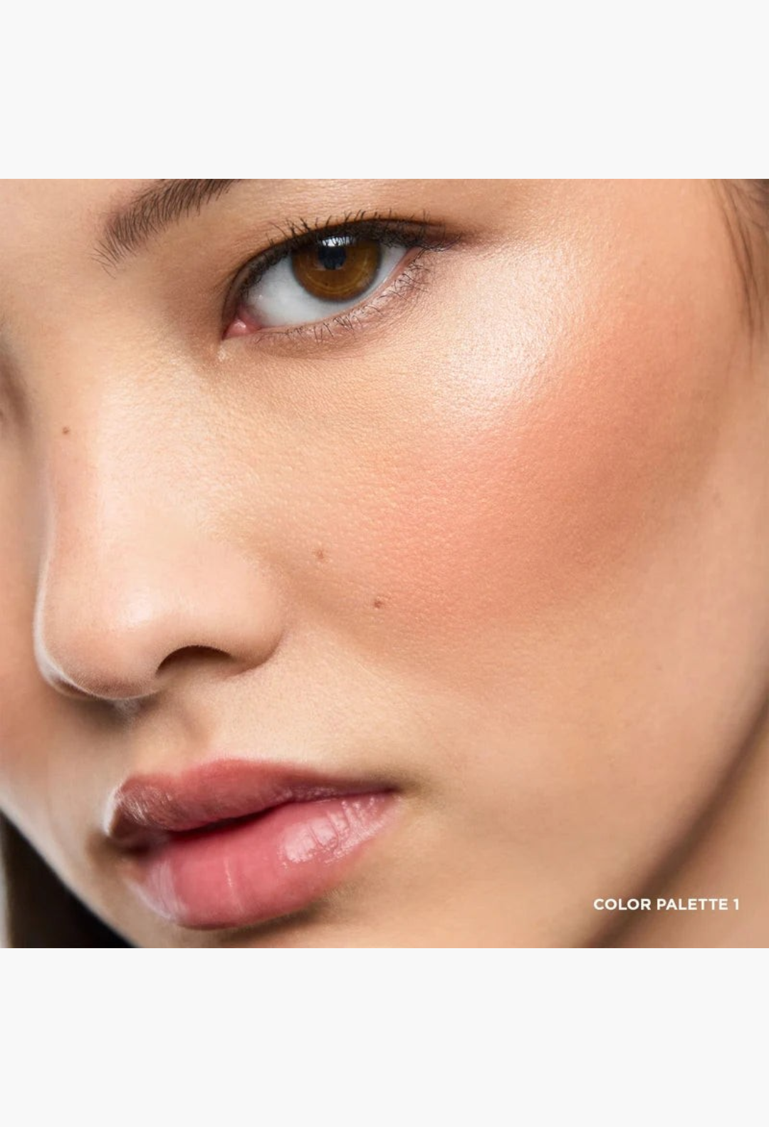 GLAM MODA Ambient Lighting Edit Unlocked Color Palette 1 applied as a soft, radiant peach blush on a model's cheek.