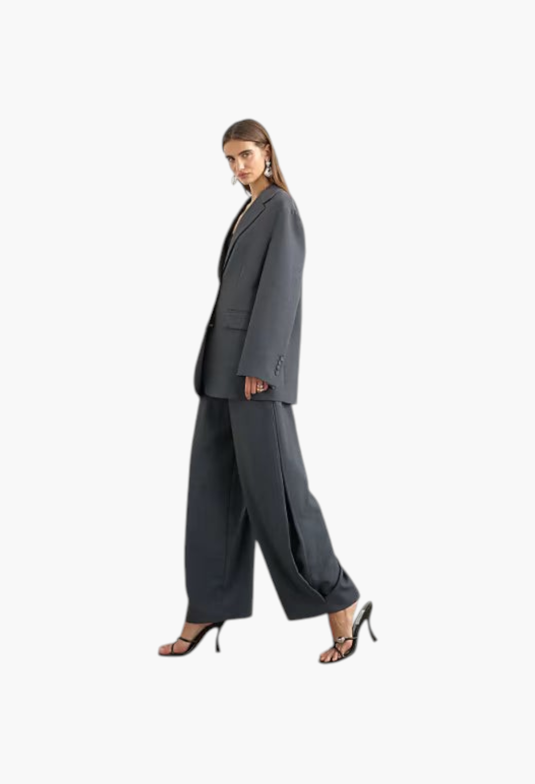 GLAM MODA model wearing grey woven barrel leg trousers with side pleats and a matching oversized blazer