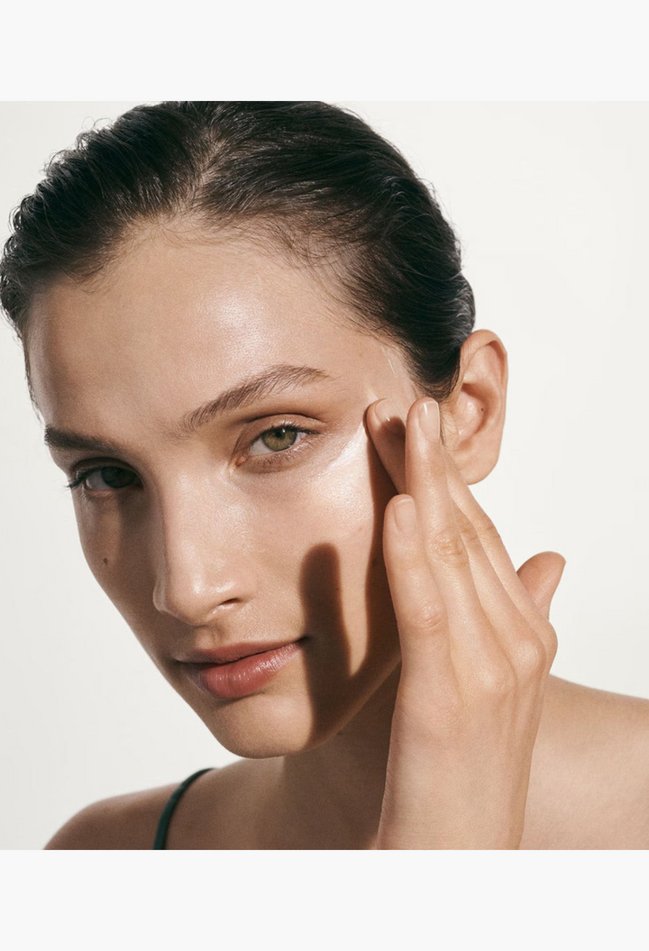GLAM MODA model applying La Mer The Moisturizing Soft Cream to her cheek for anti-ageing skincare benefits