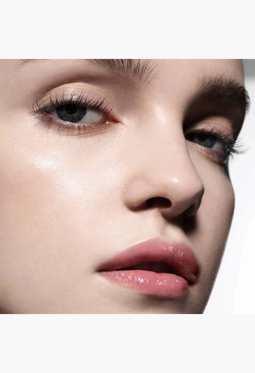 Close-up of a model wearing GLAM MODA Posh Balm, a nourishing lip shine with a glossy, sheer pink finish.
