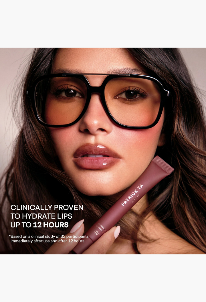 GLAM MODA mini high-shine smoothing lip balm held by a woman wearing oversized sunglasses for hydrated lips