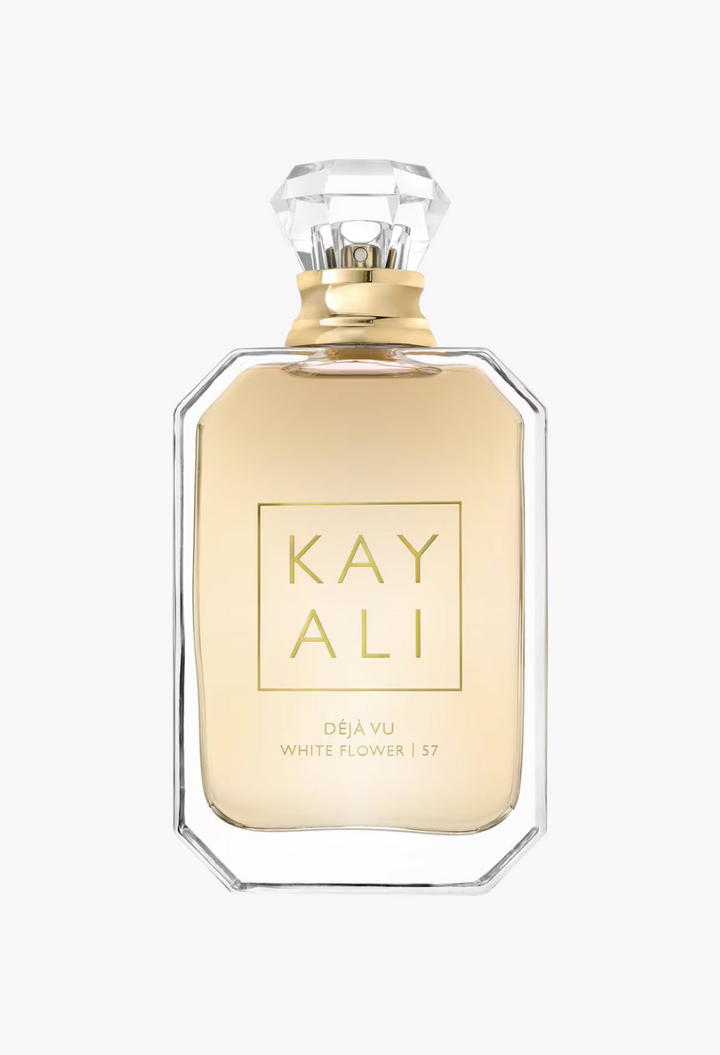 GLAM MODA Kayali Déjà Vu White Flower | 57 perfume bottle with gold liquid and a faceted crystal-style cap.