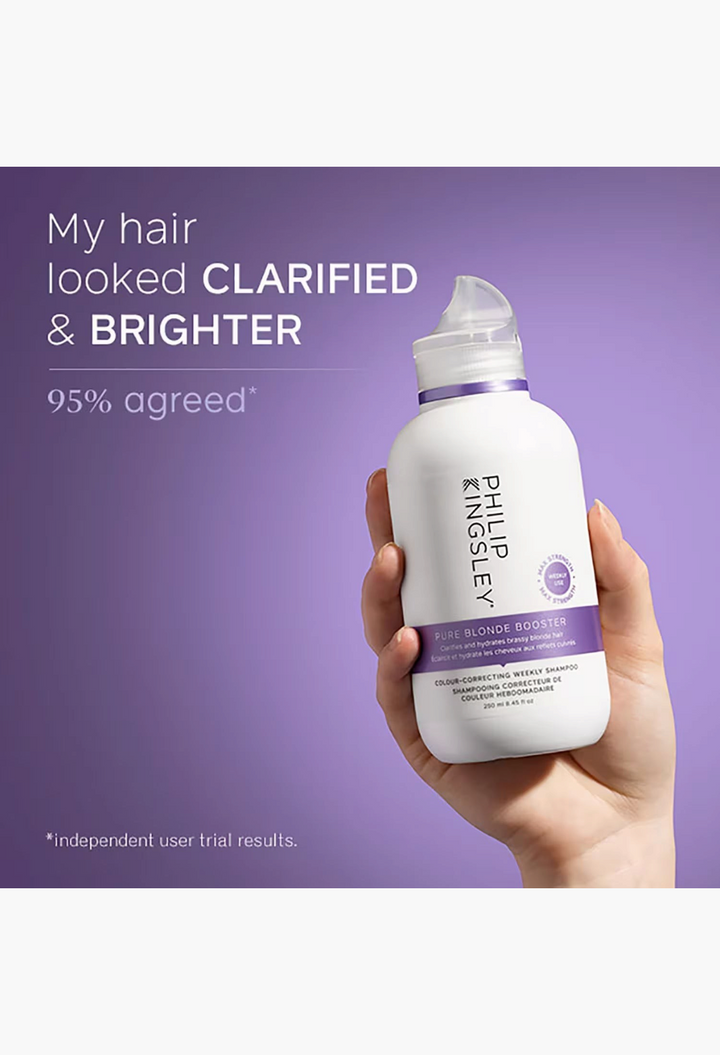 GLAM MODA Philip Kingsley Pure Blonde Booster Shampoo bottle held in hand against a purple background