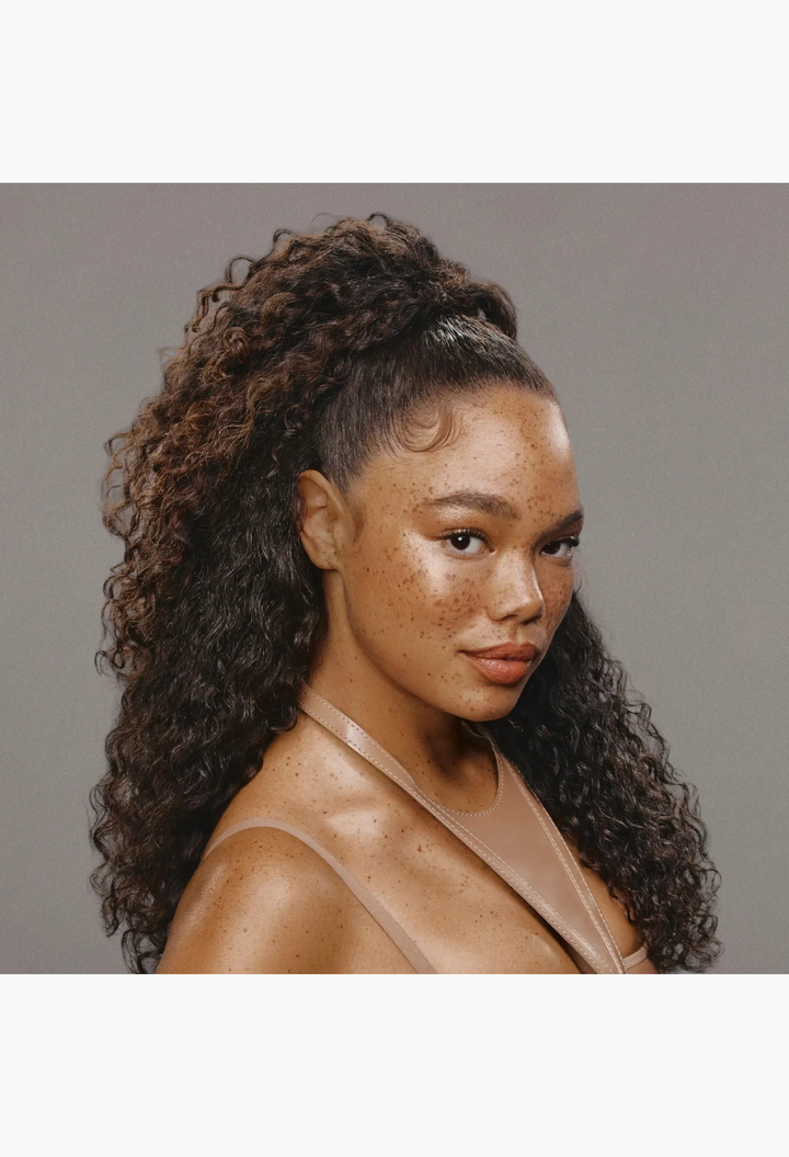 GLAM MODA Wrap & Set Foam used on a model with long, defined curly hair in a high ponytail style.