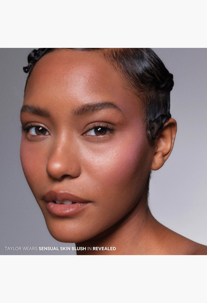Model wearing GLAM MODA The Sensual Skin Blush in Revealed, a vibrant fuchsia cream-to-powder formula on cheeks.