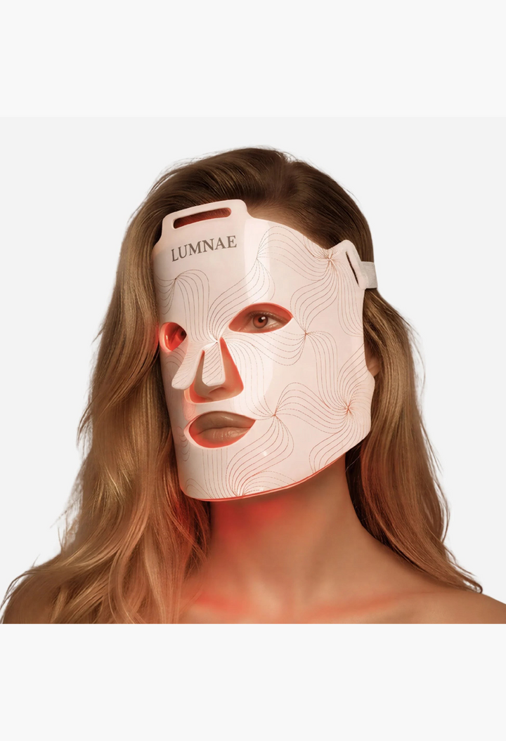 GLAM MODA Lumnae LED light therapy mask on a woman's face, featuring white medical silicone and red light emission.