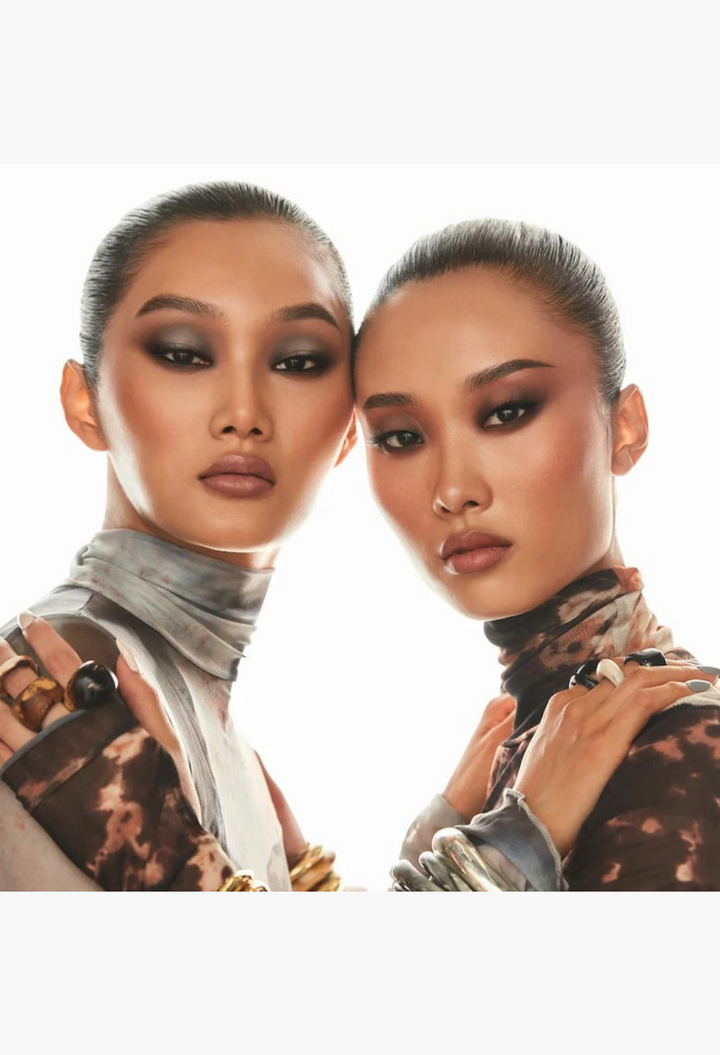 Two models wearing smoky matte eyeshadow from the GLAM MODA Major Dimension III palette with warm and cool nude tones.