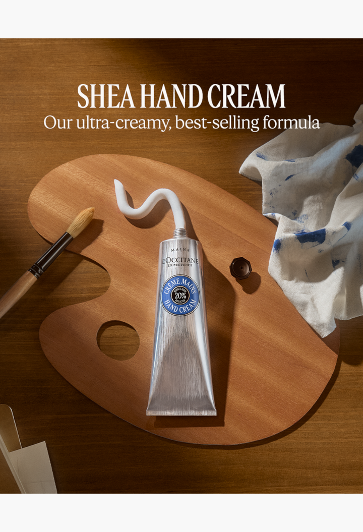 GLAM MODA Shea Hand Cream in a silver tube with white cream squeezed onto a wooden artist palette with a brush