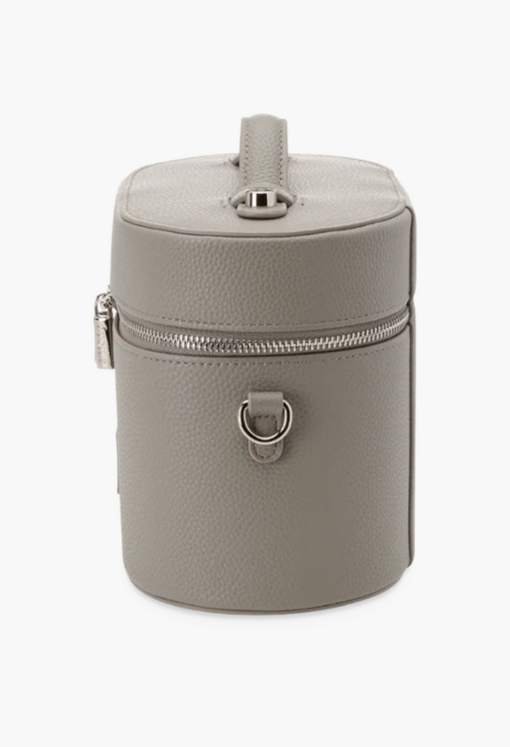GLAM MODA grey vegan leather oval toiletry case with a top handle, silver zipper, and shoulder strap attachment.