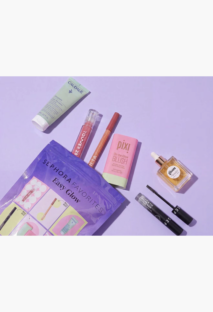 GLAM MODA Easy Glow beauty set featuring skincare, lip gloss, lipstick, brow wax, blush, and hair oil on purple