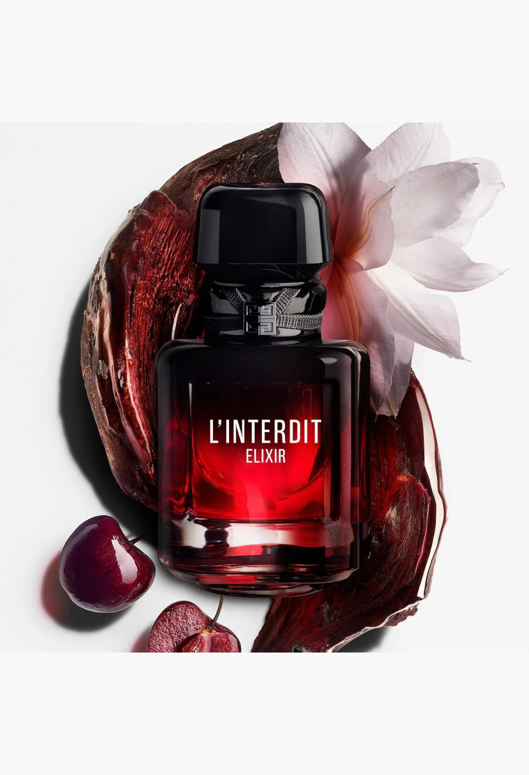 GLAM MODA L'Interdit Elixir perfume bottle with black cherry and white flower accents on a white background