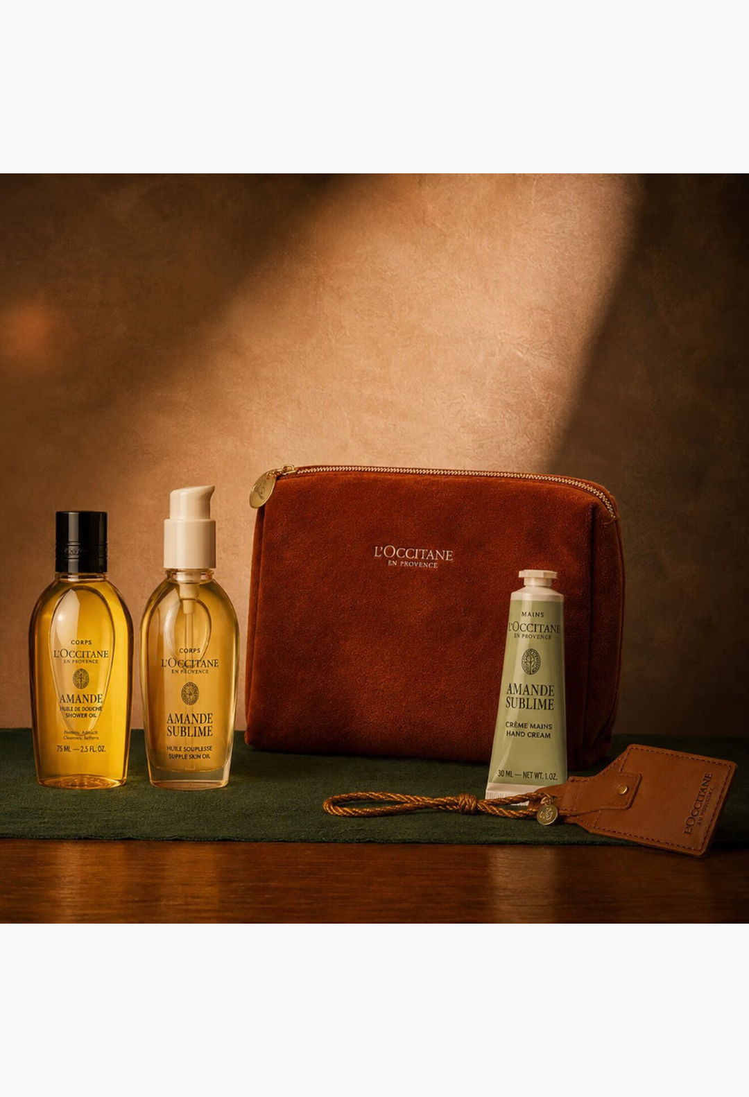 GLAM MODA Gold & Glow Almond set featuring shower oil, supple skin oil, and hand cream in a brown velvet pouch.