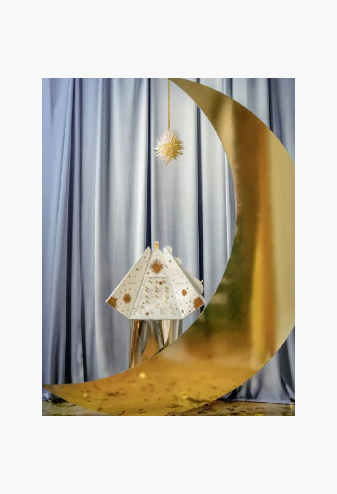 GLAM MODA Laduree 2026 advent calendar with gold celestial designs, displayed with a large gold crescent moon prop.