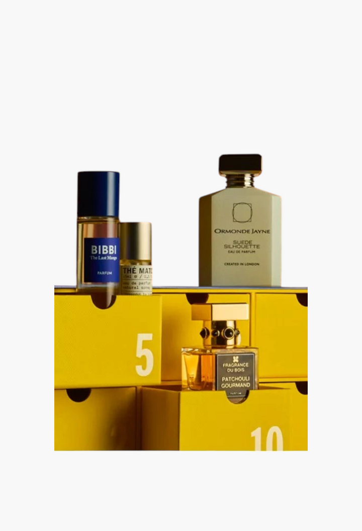 GLAM MODA Fragrance Advent Calendar 2026 featuring luxury perfume bottles displayed on bright yellow numbered drawers.