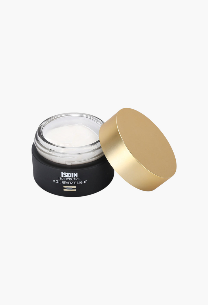 GLAM MODA Isdinceutics A.G.E. Reverse Night Cream in a black jar with a gold lid and white anti-aging face cream.