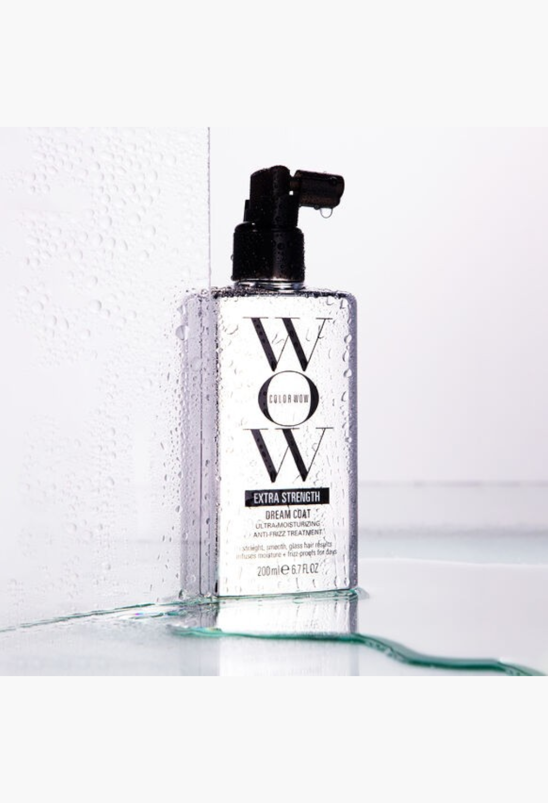 GLAM MODA Color Wow Extra Strength Dream Coat anti-humidity hair spray bottle with water droplets on a white background