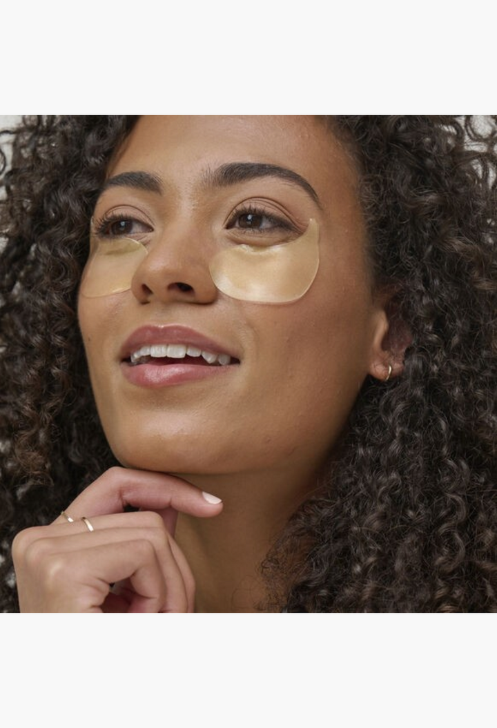 GLAM MODA model wearing pearlescent Patchology FlashPatch illuminating hydrogel eye masks for dark circles