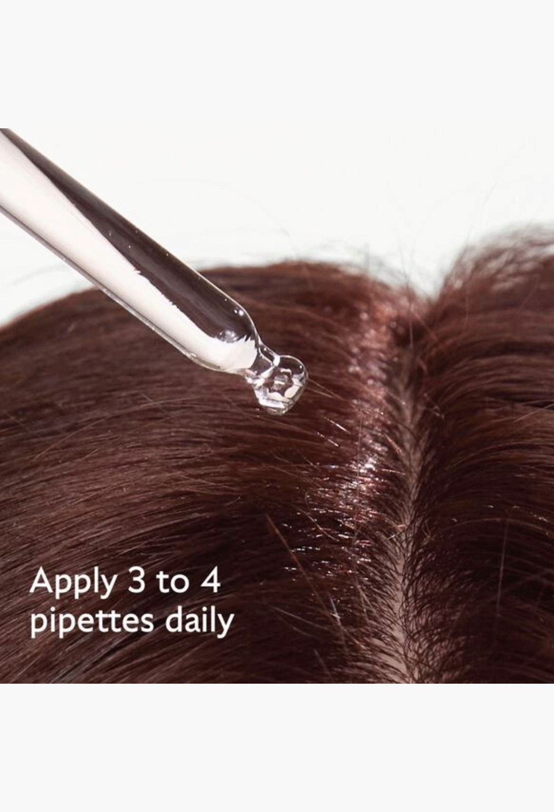 GLAM MODA anti-hair loss serum being applied to a brown hair scalp with a glass pipette dropper