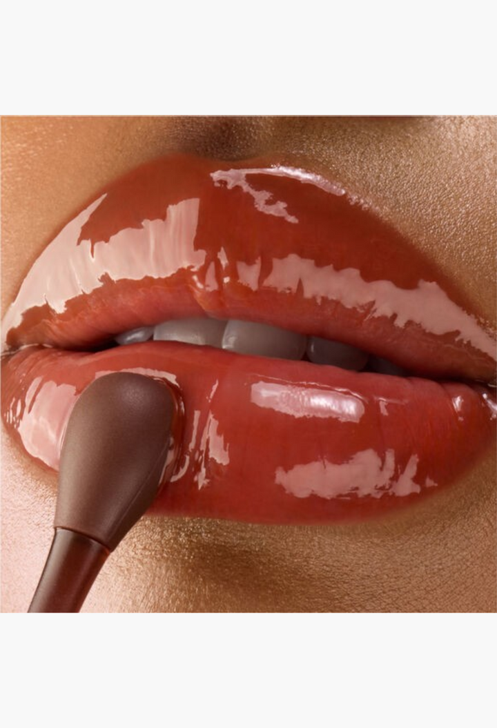 GLAM MODA Gisou Cherry Chocolate lip mask being applied with an applicator for a high-shine, glossy finish.