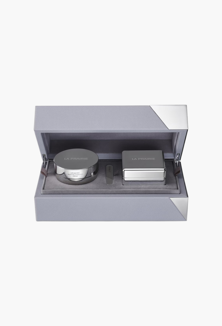 GLAM MODA La Prairie Life Matrix Longevity Capsule set featuring a rejuvenation cream jar and massager in a grey case.