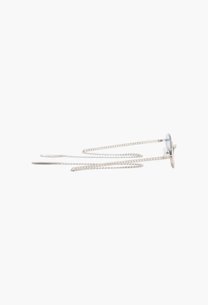 GLAM MODA Gaga sunglasses in gold metal with sculptural frames and decorative chain temples on a white background.