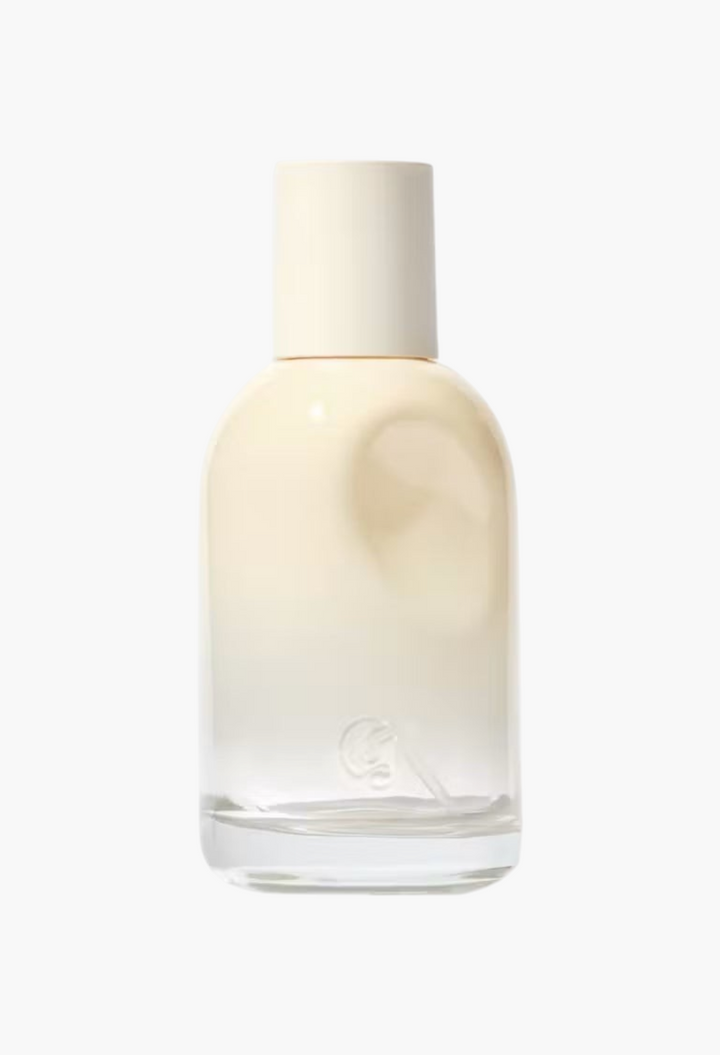 GLAM MODA Glossier You Doux eau de parfum in a minimalist glass bottle with a cream-colored cap.