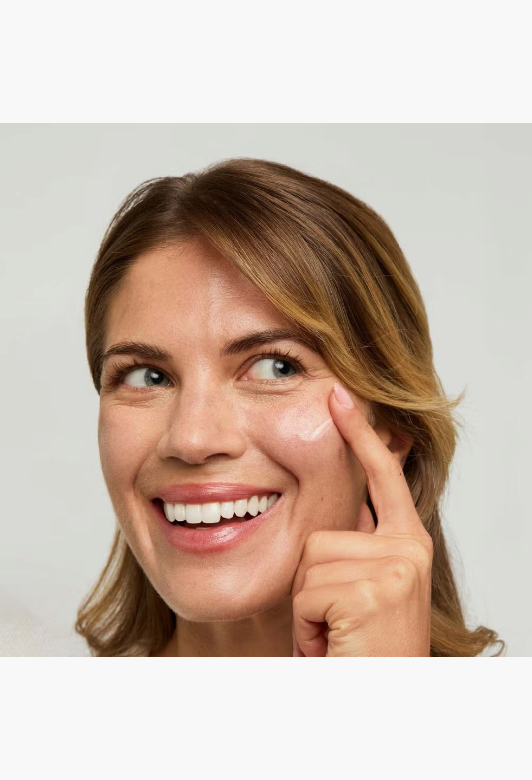 GLAM MODA model applying illuminating gel primer to cheekbone for a radiant, smooth base and healthy glow
