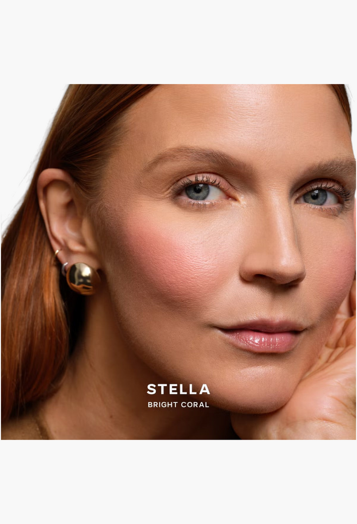 GLAM MODA model wearing Saie SuperSuede Radiant Blush in Stella bright coral shade for a natural glowing flush