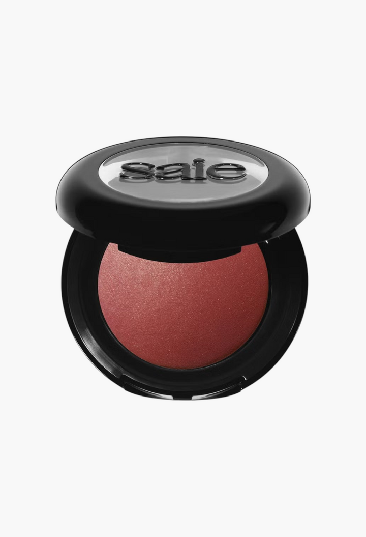 GLAM MODA Saie SuperSuede Radiant Blush in a round black compact with a soft-focus, pigmented powder finish.