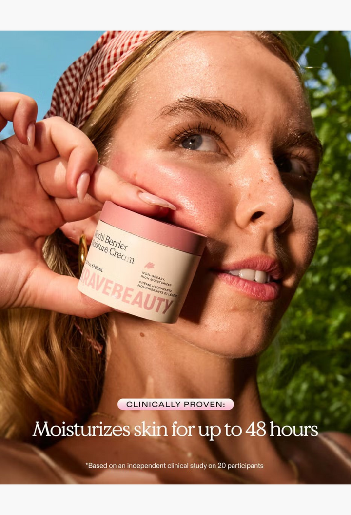 GLAM MODA model holding a jar of KraveBeauty Mochi Berrier Moisture Cream against her glowing, hydrated cheek.