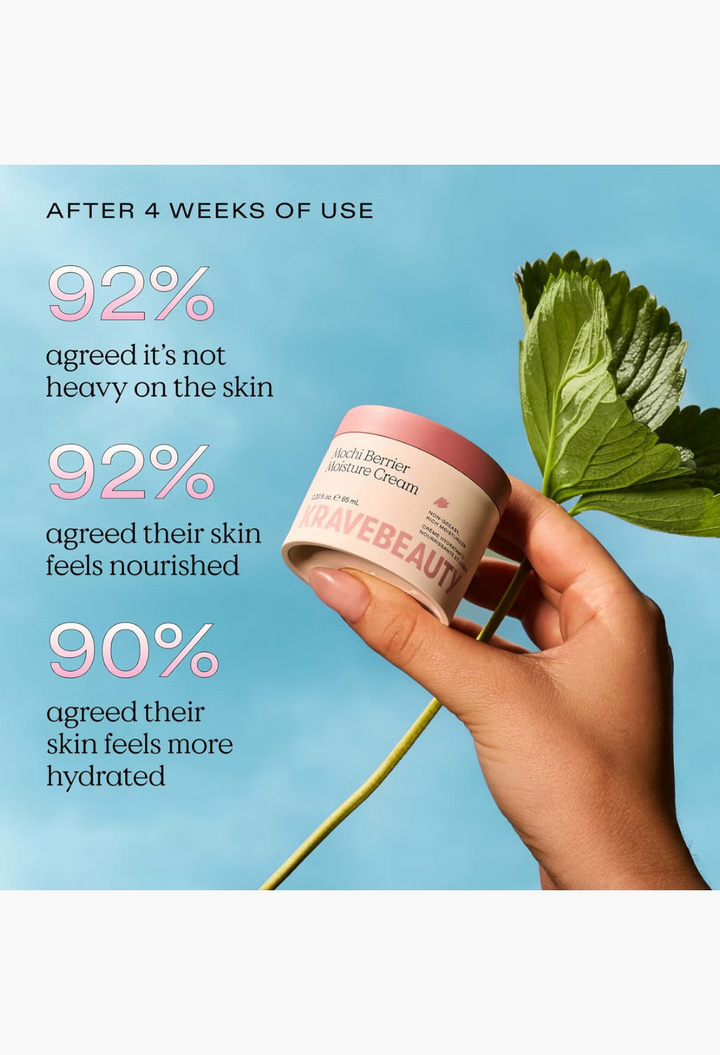 GLAM MODA KraveBeauty Mochi Berrier Moisture Cream jar held in hand next to a fresh strawberry leaf