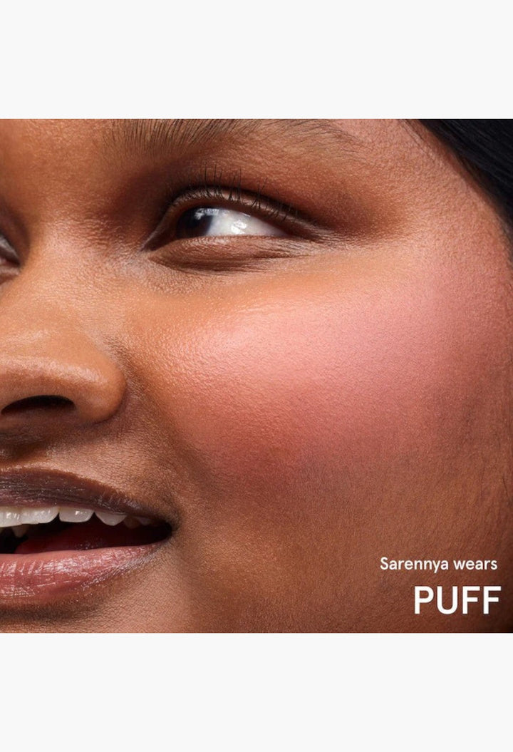 GLAM MODA Cloud Paint gel-cream blush in shade Puff applied to a model's cheek for a soft, dewy, sunset-inspired flush