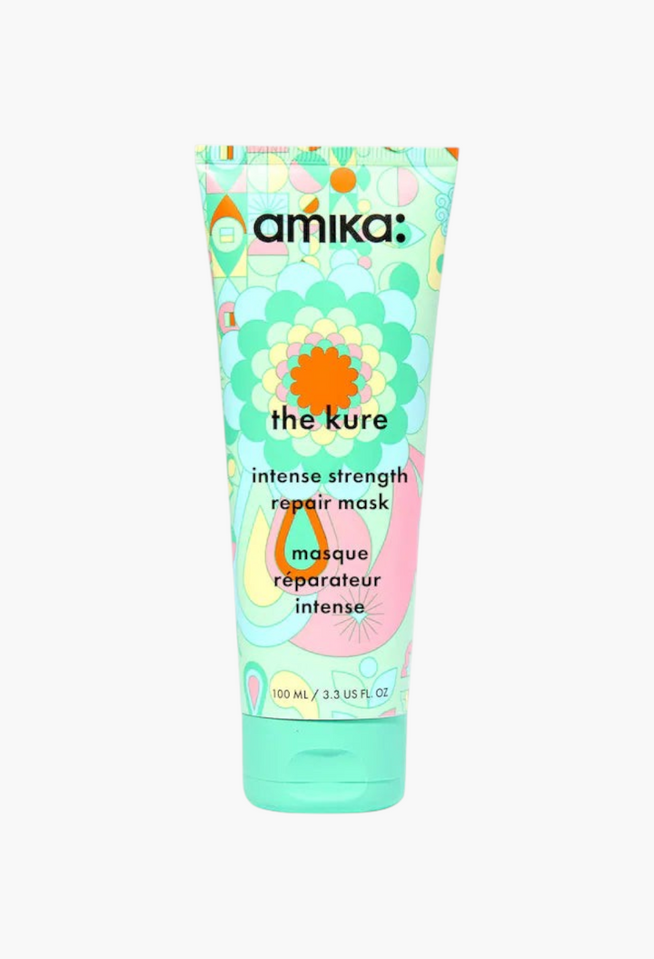 GLAM MODA amika The Kure Intense Strength Repair Hair Mask in a light green squeeze tube with colorful floral patterns.