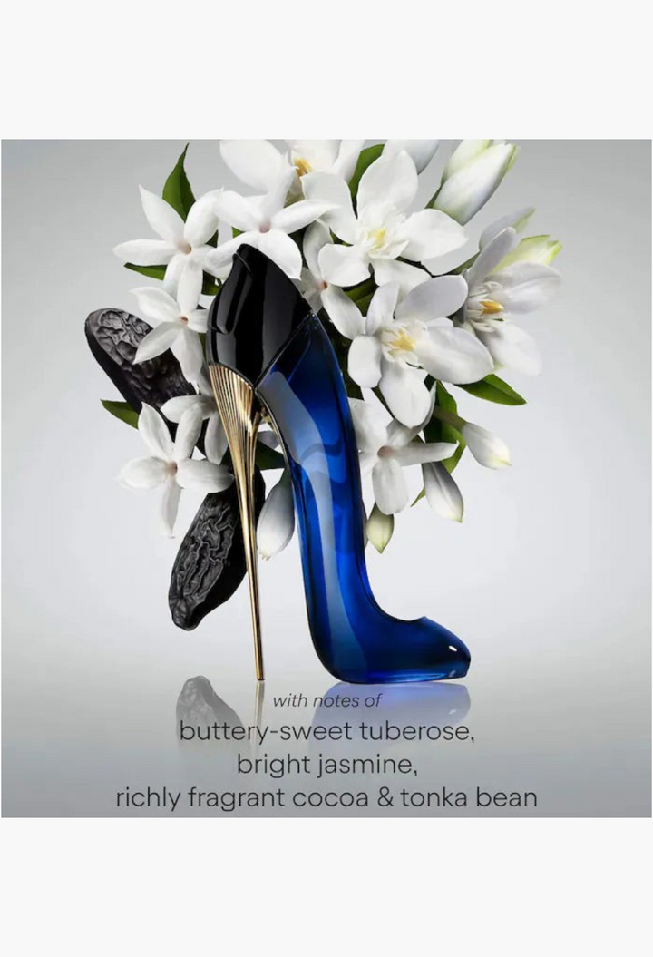 GLAM MODA Carolina Herrera Good Girl perfume bottle shaped like a blue stiletto heel with white jasmine flowers