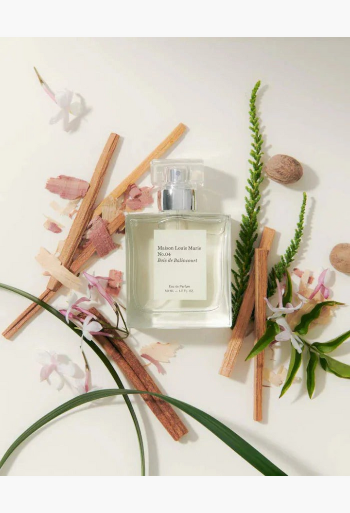 GLAM MODA Maison Louis Marie No.04 Bois de Balincourt perfume bottle surrounded by wooden sticks and botanical elements