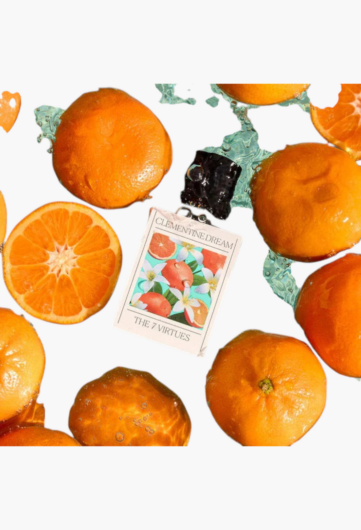 GLAM MODA perfume sample of The 7 Virtues Clementine Dream surrounded by fresh orange slices and splashing water