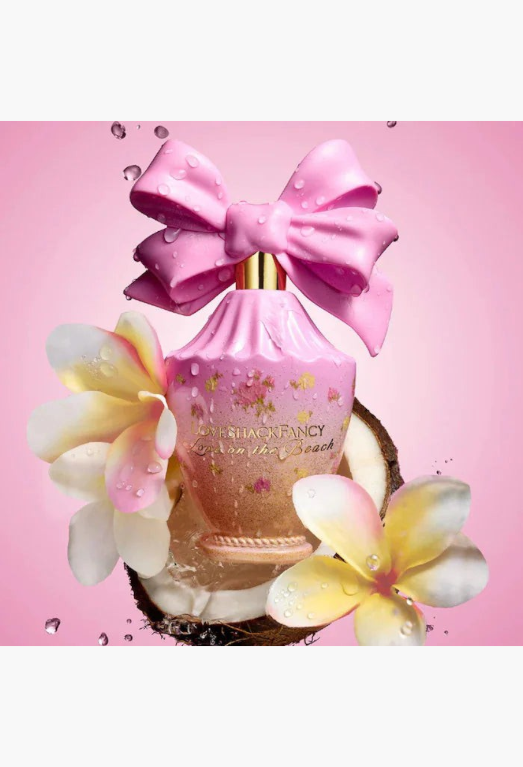 GLAM MODA LoveShackFancy Love On The Beach perfume bottle with a pink bow, tropical flowers, and coconut shell.