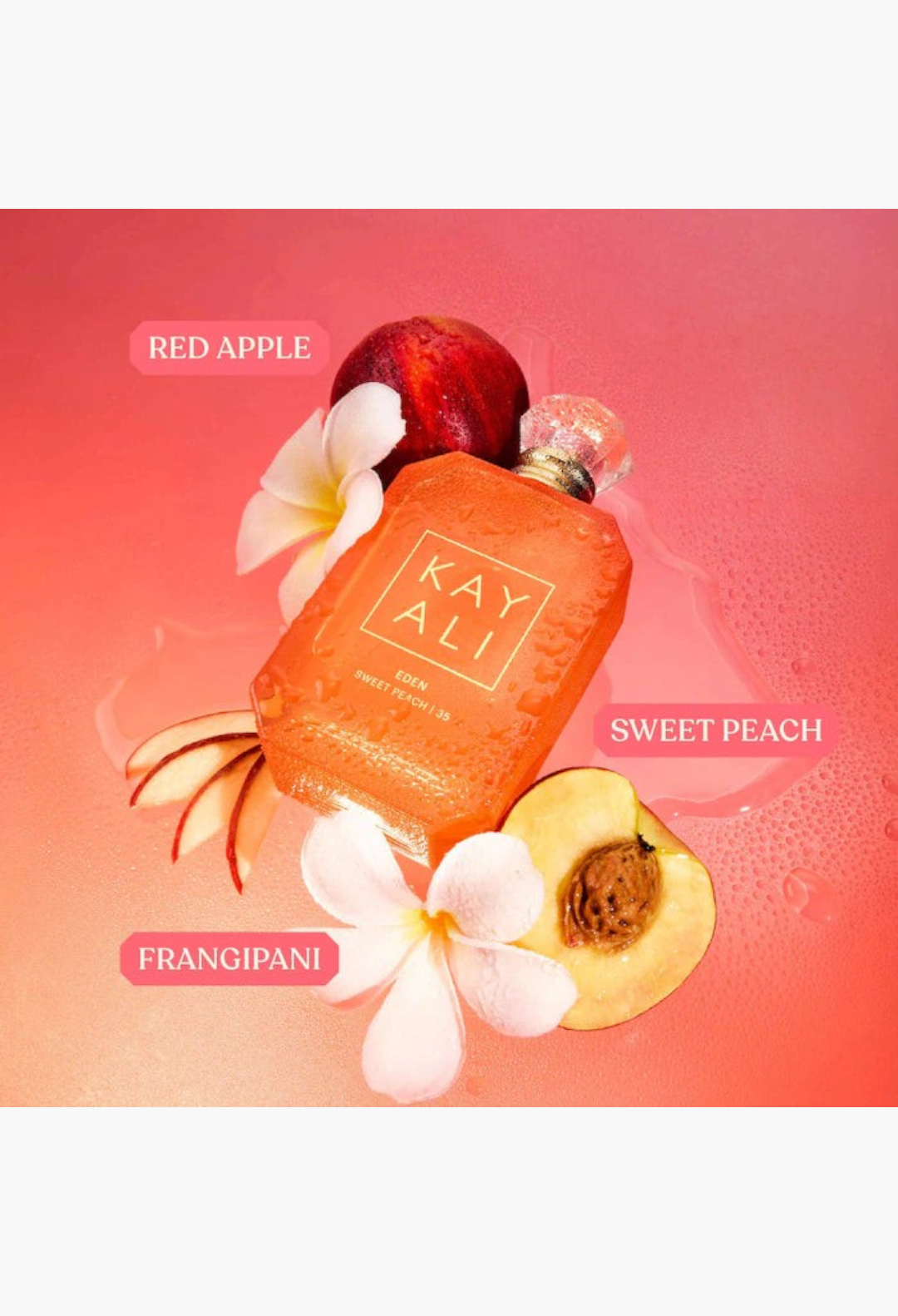 GLAM MODA Kayali Eden Sweet Peach perfume bottle surrounded by fresh peach slices and tropical flowers