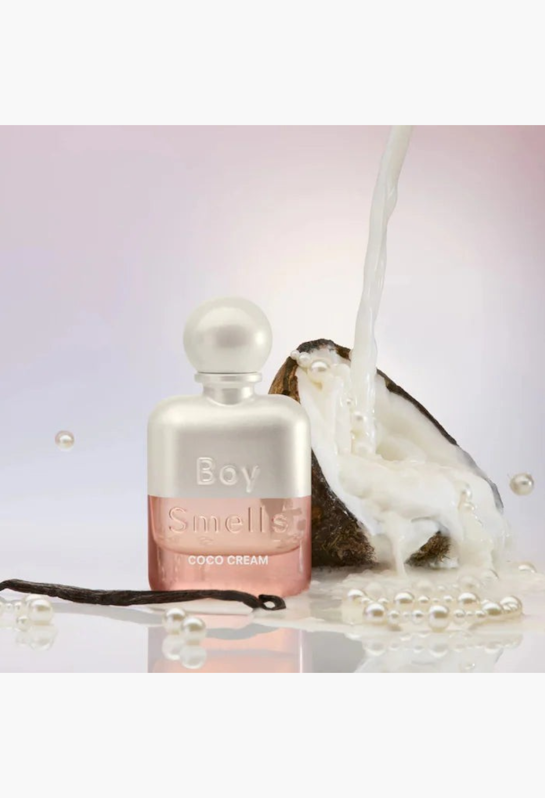 GLAM MODA Boy Smells Coco Cream perfume bottle with coconut milk pouring, pearls, and vanilla bean on a soft background