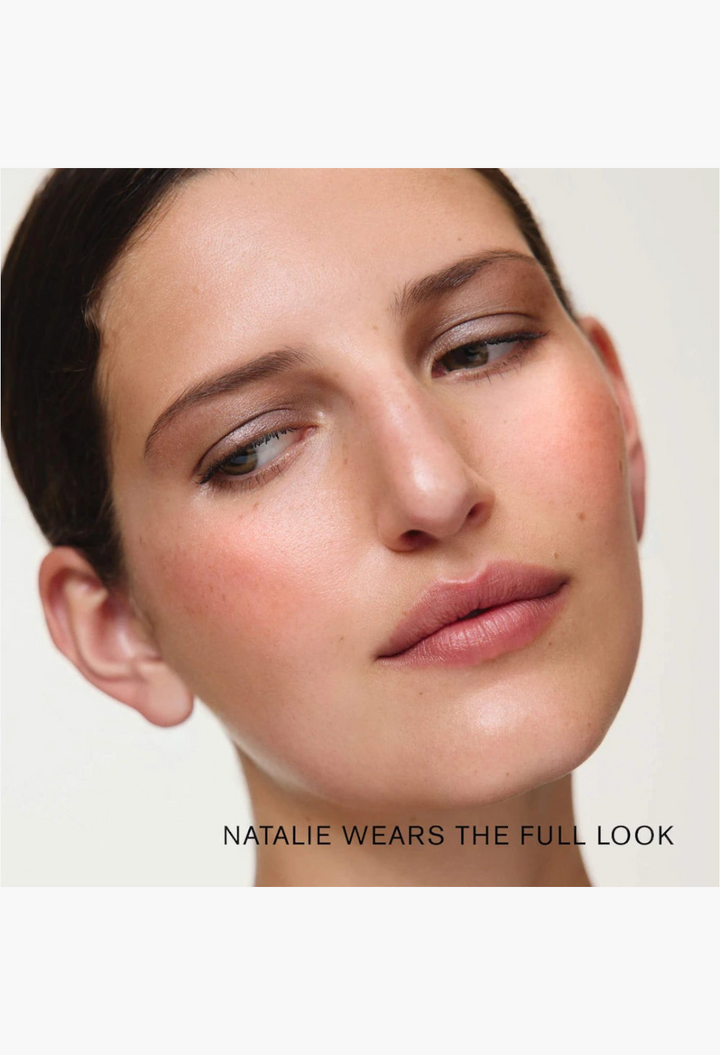 Model wearing the GLAM MODA MERIT x Erdem makeup set featuring soft shimmer eyeshadow, cream blush, and highlighter.