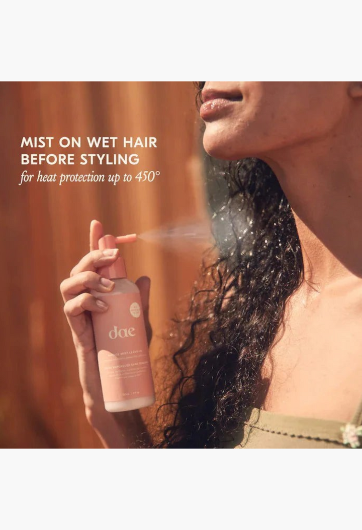 GLAM MODA model spraying Dae Mirage Mist leave-in conditioner on curly hair for heat protection