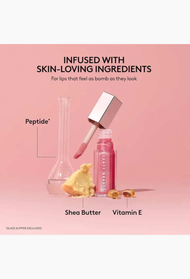 GLAM MODA Gloss Bomb lip luminizer with peptide, shea butter, and vitamin E ingredients on a soft pink background