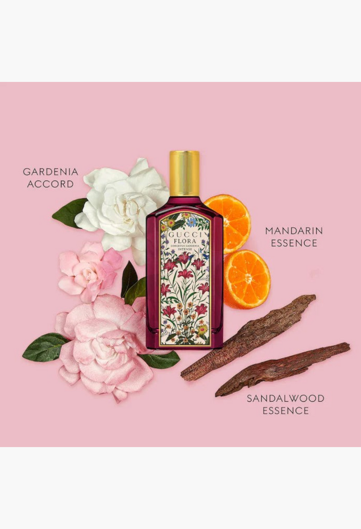 GLAM MODA Gucci Flora Gorgeous Gardenia perfume bottle surrounded by gardenia flowers, mandarin slices, and sandalwood.